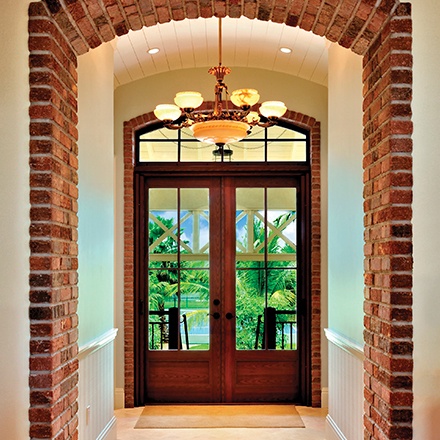 The mahogany red wood on this WinDoor estate entrance works perfectly with the brick detailing in this home.