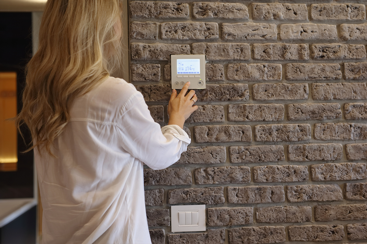 Luxury homeowner adjusts smart home thermostat