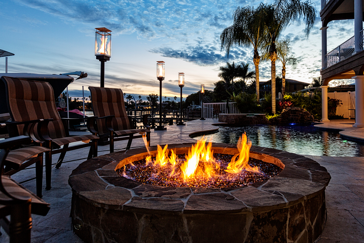 A fire pit next to the pool in a luxury coastal home