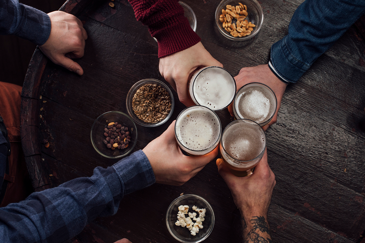 Friends share drinks on a barrel bar