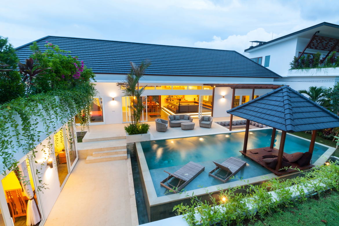 Luxury poolside furniture elevates this coastal home with WinDoor sliding glass doors.